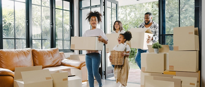 Woman cheering as she enters new home with boxes
