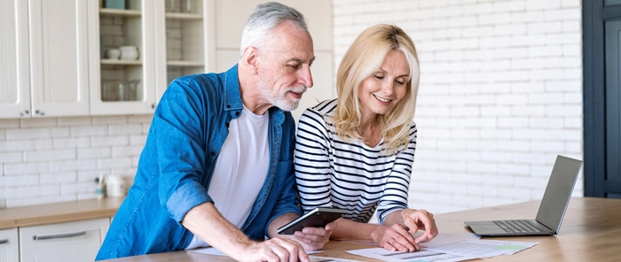 Mature couple in kitchen with paperwork